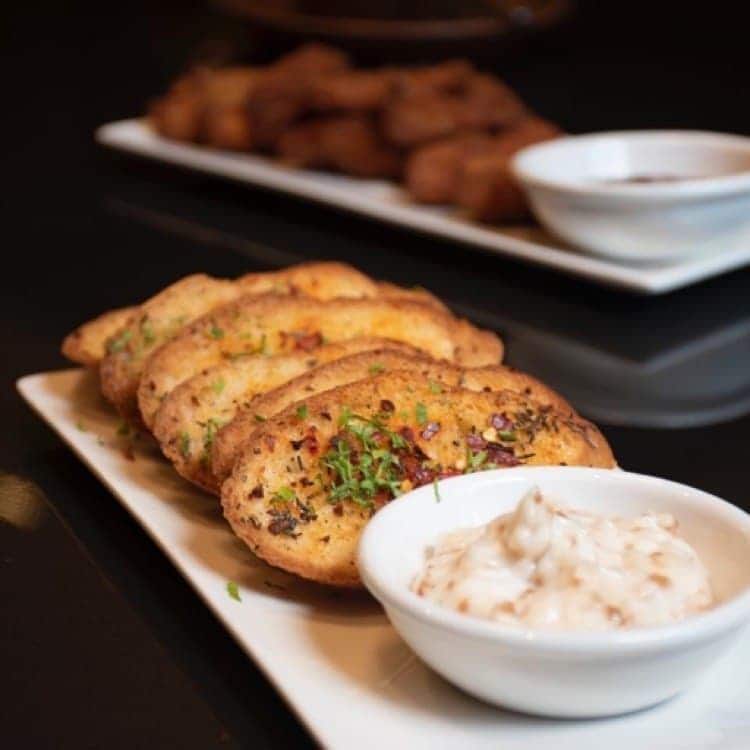 Plated garlic bread with dip at Bougainvillea